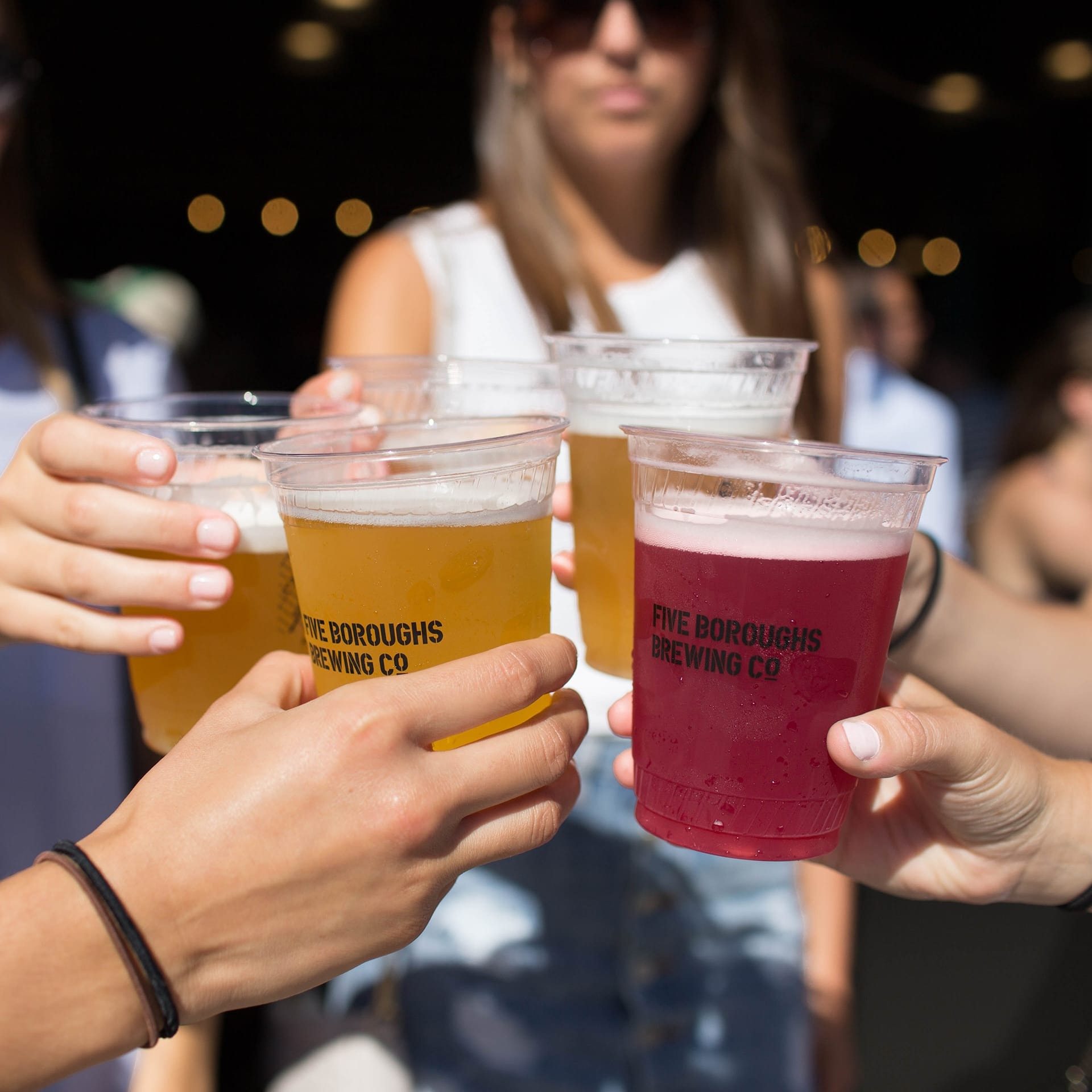 people holding up cups of beer for cheers