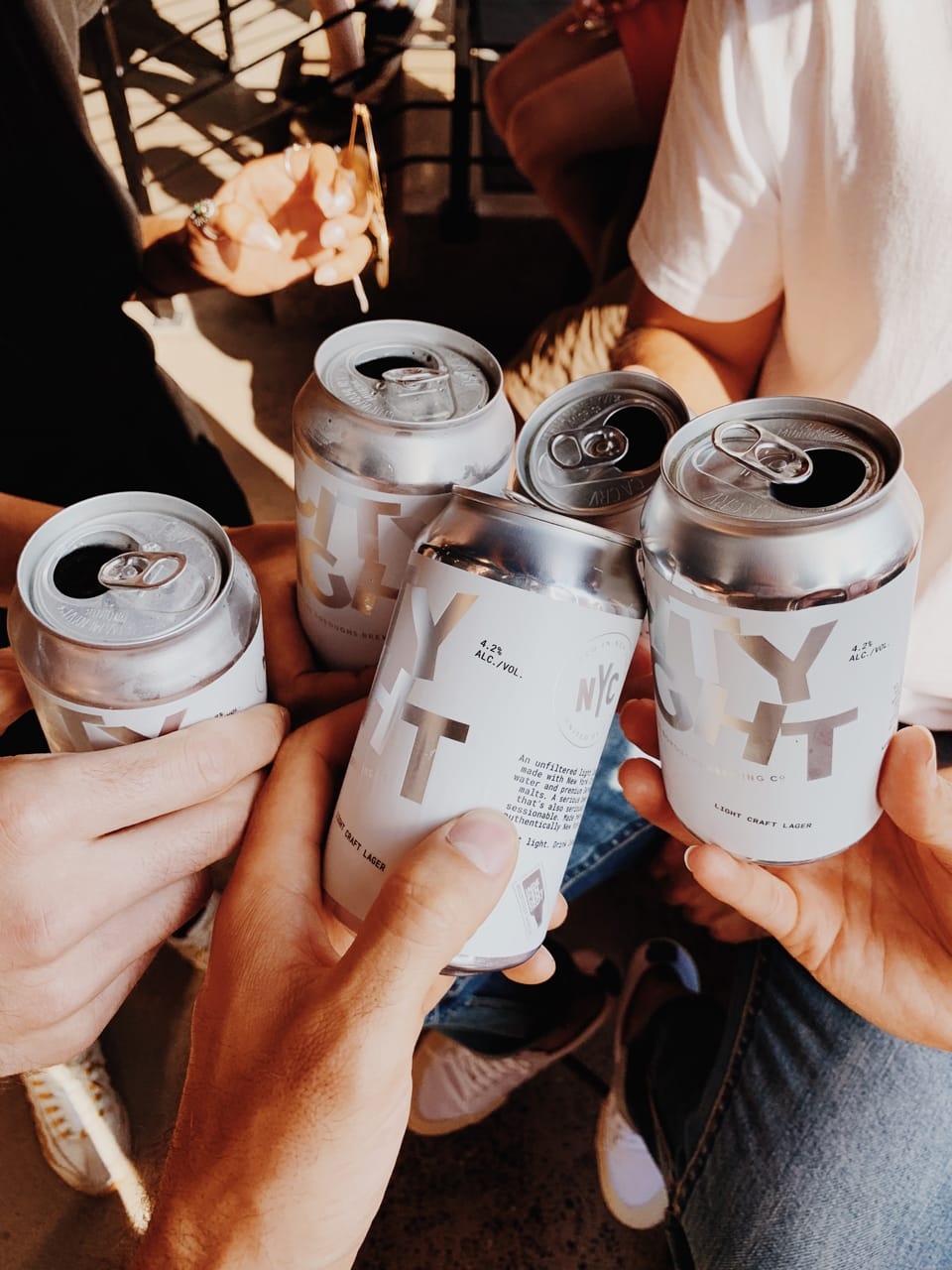 people holding city light beer cans for a cheer